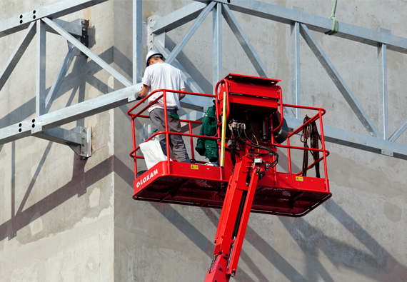 Profissional realizando ajustes em galpão com a plataforma elevatória
