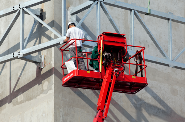 Profissional realizando ajustes em galpão com a plataforma elevatória
